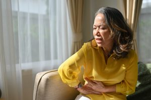 senior woman experiencing discomfort from bloating in menopause