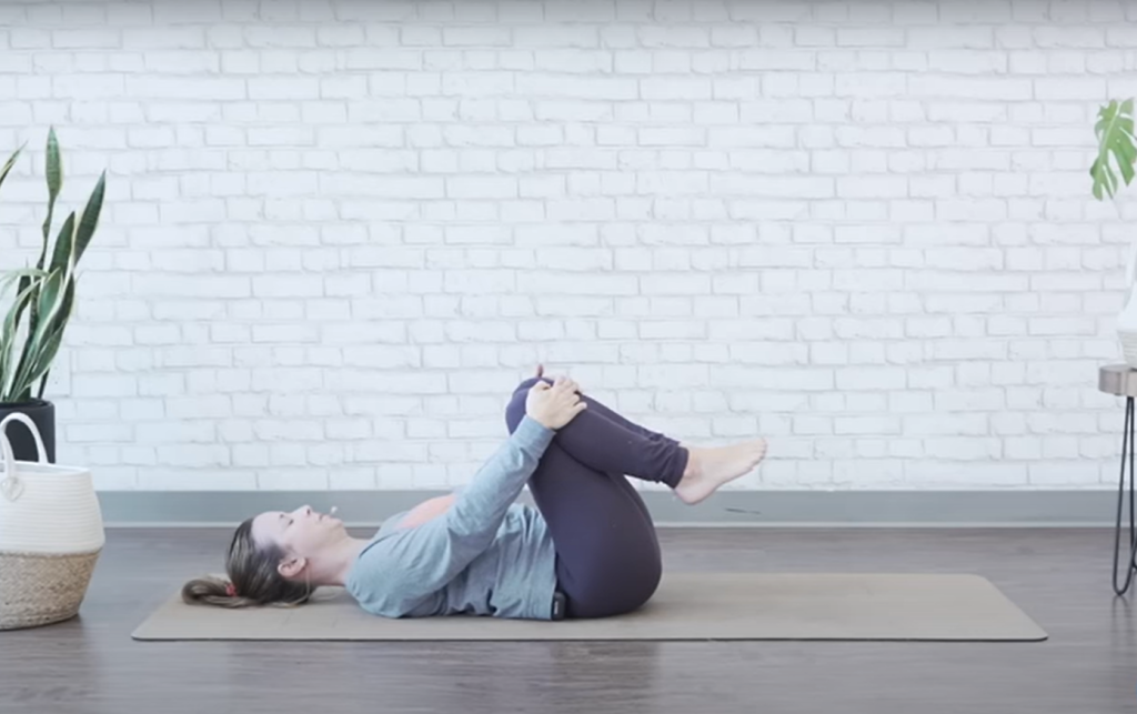 Demonstrating the knee-to-chest bed exercise - starting position